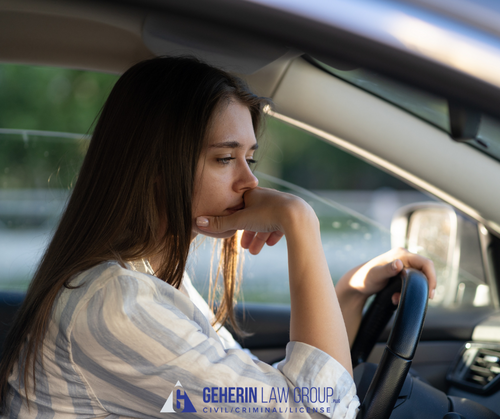 a lady behind the wheel of a car looking worried